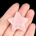 Hand holding a star-shaped natural rose quartz crystal with polished pink texture - Rose Quartz