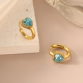 Golden heart earrings with light blue zircon stones on a decorative stone base - Blue