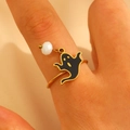 Detalle de anillo dorado con colgante de fantasma negro y cuenta blanca en dedo - Estilo Fantasma (05 Oro Real 18K DZ-421)
