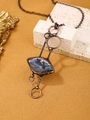 Detailed close-up of a vintage bronze labradorite pendant with iridescent blue shine - Labradorite