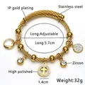 Dettaglio macro del bracciale a cavo in acciaio placcato oro 18K con ciondolo a croce - Oro 18K / Oro