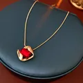 Golden snake chain necklace featuring a rectangular red gemstone pendant in luxury style - Red Necklace