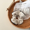 Beige ribbed scrunchie with black trim presented in a natural woven basket - Beige Goddess Contrast