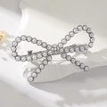 Detail of elegant bow hair clip with pearls and rhinestones on a white stone base - Pearl Silver