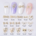 Various alloy 3D bow nail charms with pearls and rhinestones shown in 15 styles - Hollow Rhinestone Bow Style (8680) / Gold