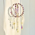 Close-up of handmade gold suncatcher with purple amethyst stones and crystal prisms - Amethyst
