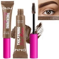 Detail showing brown brow mascara wand with hair-like fibers and creamy texture display - Brown