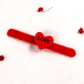 Plush red Christmas slap bracelet with heart decoration and LOVE print on white fur background - Heart