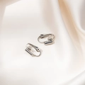 Macro di convertitori per orecchini a clip in argento su elegante seta bianca pura - Argento