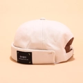 Beige brimless docker cap with black square woven label in retro Japanese street style - Peeping Label Beige