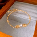 Macro detail of gold iris pendant bracelet with oval zircon in a linen jewelry box - Gold