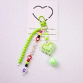 Close-up of handmade green LOVE beaded keychain with a pixel heart pendant and smile bead - Green