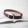 Deep brown leather belt with silver brushed square buckle on minimalist magazine background - Coffee