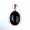 Oval black agate pendant set in a polished gold bezel with a matching gold bail - Black Agate