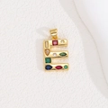 Macro view of golden letter E pendant with multi-colored crystals and zircon stones - Letter E
