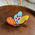 Colorful acetate butterfly hair claw clip with rhinestones shown on a wooden tray - Pink-Blue-Yellow Rhinestone Drip Oil Butterfly