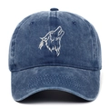 Detailed view of white wolf head embroidery on a vintage washed blue denim baseball cap - Adjustable / Navy Blue