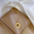 Goldene Lebensbaum-Halskette mit Kristallen auf einer beigen Schmuckschatulle mit Seide - Gold