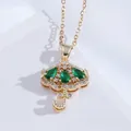 Close-up of gold umbrella pendant necklace with green zircons and diamond details - Green Umbrella