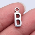 Silver alloy letter B pendant charm for DIY jewelry making shown held by fingers - Letter B (B15655) / Antique Silver
