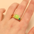 Primer plano de anillo vintage dorado con gema verde cuadrada y detalles de colores - Estilo Piedra Verde (DZ-301) / Oro KC