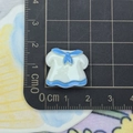 Detail shot of a 2cm blue and white sailor uniform resin charm on a measuring mat - Blue White Dress