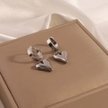 Macro shot of silver heart pendant hoop earrings on soft silk fabric and jewelry box - Silver Polished Heart Pendant Hoop