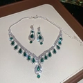 Vista macro di collana da sposa e orecchini a smeraldo su un vassoio da esposizione - Argento Verde Smeraldo