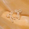 Elegant gold bow earrings with white pearls displayed on soft champagne silk fabric - Bowknot Tassel Artificial Pearl Style (NMSE-D434-2)