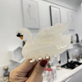 Macro detail of swan cellulose acetate hair claw with white marble pattern and orange beak - Mermaid Pearl Rhinestone White Swan (8cm)