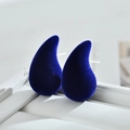 Detail view of dark blue velvet teardrop earrings placed on a white leather jewelry box - Sapphire Blue