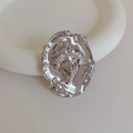 Detailed close-up of matte silver vintage art deco face brooch with smooth metallic finish - 1 Piece / Silver