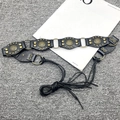 Close-up of black leather Y2K belt featuring brass rivets and round metal ring connectors - Six Flower Lace-up Style / Black