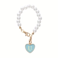 Detail of pearl chain with a light blue heart pendant featuring a gold letter U charm - Letter U