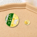 Round enamel bunny pin with 'Good Times' text on a cork tray with newsprint - Good Times Jade Rabbit