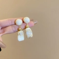 Detail of cream marble resin drop earrings with elegant golden metal knot link - White