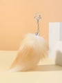 Close-up of fluffy orange and cream faux fox fur tail keychain with silver metal ring - Bleach Blonde