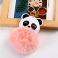 Macro-opname van panda pluche sleutelhanger met roze pompon en gouden metalen sluiting - Koreaans Roze