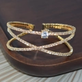 Luxurious gold crossover open bangle featuring sparkling pavé crystals and a round center stone - Gold