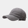 Close-up of a dark grey baseball cap with silver safety pin and metal rings detail - Gray