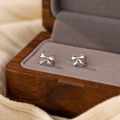 Elegantes pendientes de lazo plateado en un lujoso joyero de madera para regalo - Oro Blanco