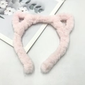 Draufsicht auf einen weichen rosa Katzenohren-Haarreif aus Plüsch auf hellem Hintergrund - Katzenohr / Kurz / Rosa