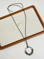 Detail view of a silver flower pendant necklace with leopard print on a linen display tray - Coffee Leopard