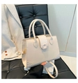 Detail of cream white tote bag with crocodile texture panels on a black leather chair - Khaki