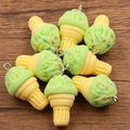 DIY light green resin ice cream cone charms with colorful sprinkles on wood background - Green