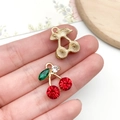 Macro shot of rhinestone cherry pendant on fingertip showing intricate double-sided detail - KC Gold Red Rhinestone Fruit Cherry (23414)