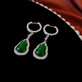 Macro-opname van groene hars kalebas oorbellen met zirkoon inleg op zwart fluweel - Groene Gourd Ring