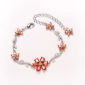 Elegant silver bracelet with orange five-petal flowers and crystal leaf accents - Orange-White Gold