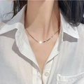 Collana piatta a serpente in acciaio al titanio argento indossata da una modella in camicia - Larghezza 2,5 mm (Argento) / 40+6cm