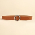 Close-up of brown leather belt with silver twisted round metal buckle on beige background - Camel